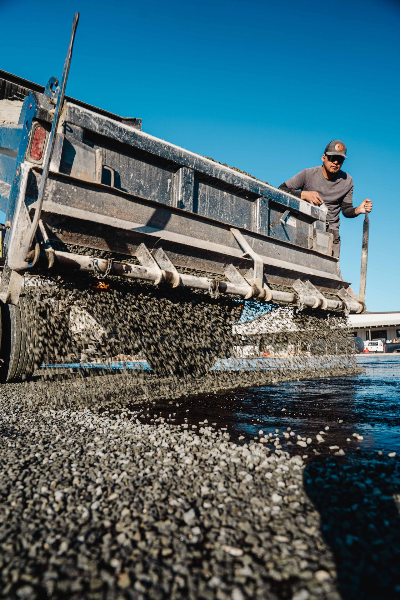 Aggregate moving through a spreader during road work