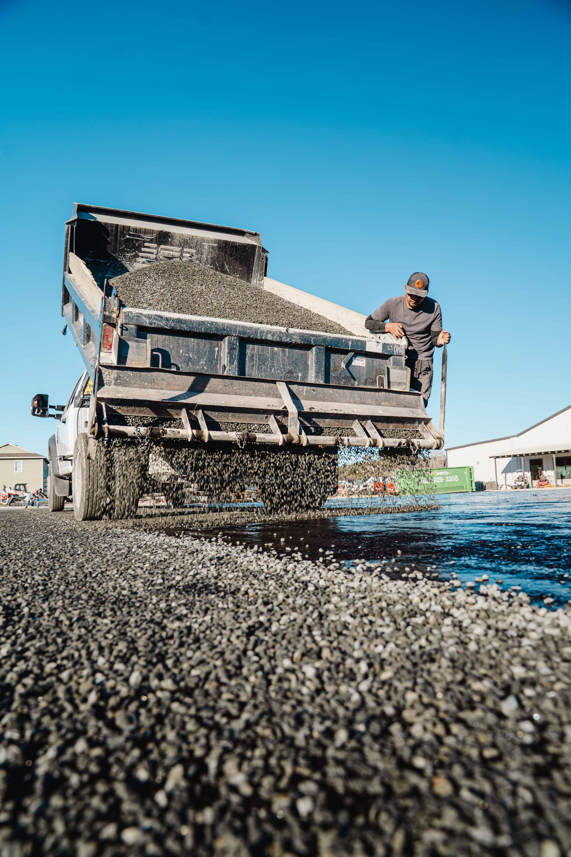 Aggregate being placed during chip-seal installation