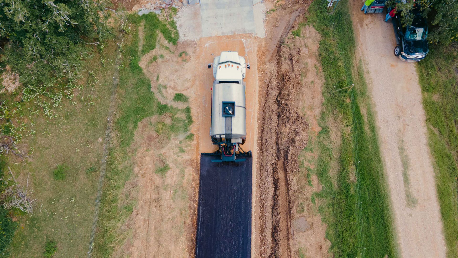 Aerial view of a distributor truck applying material during chip-seal work