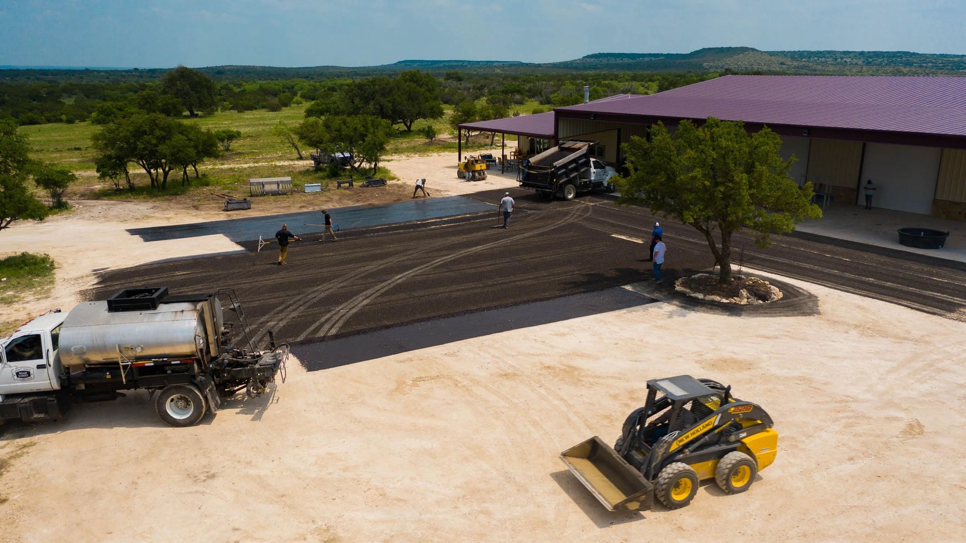 Aerial view of chip-seal work across a large managed-property surface