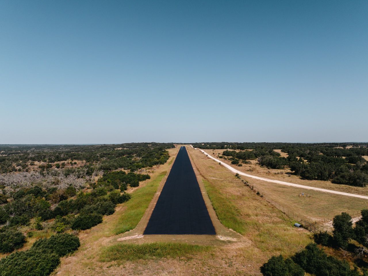 Later uniform dark surface along the same long straight road