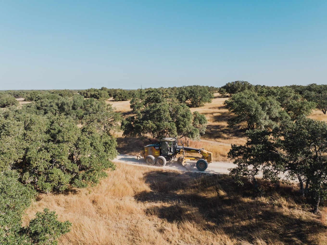 Aerial view of a motor grader shaping a rural road