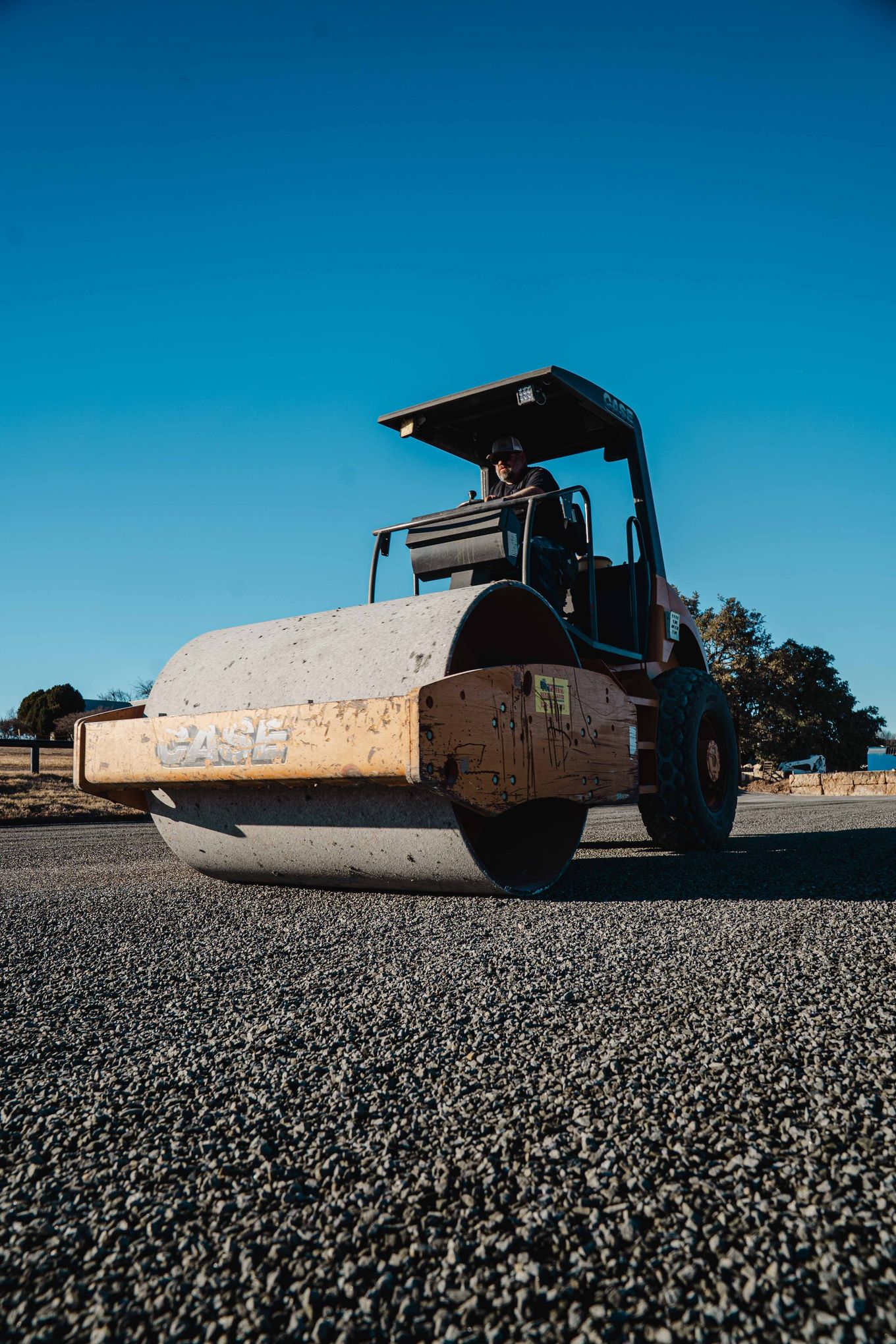 Pneumatic roller compacting newly placed aggregate