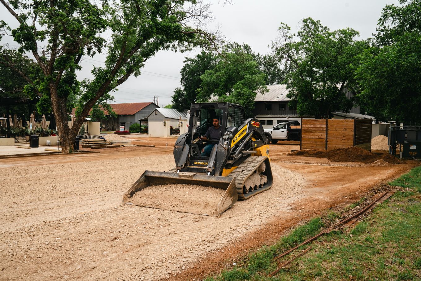 Skid-steer preparing a road base before surfacing