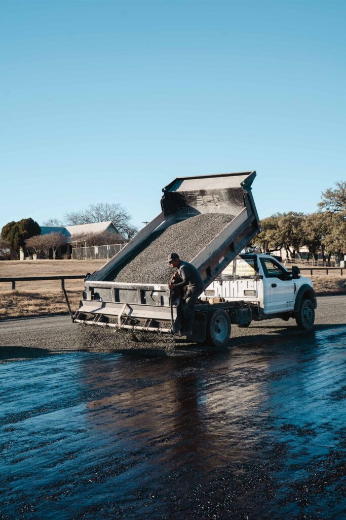 Chip seal aggregate spreading from a Rafferty Paving truck