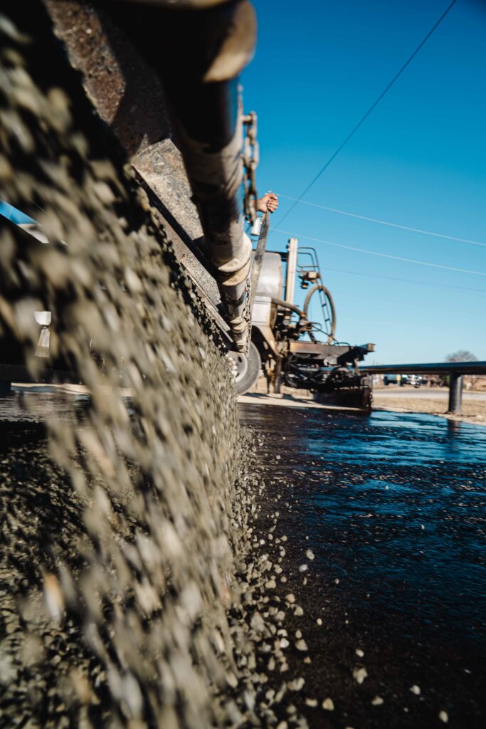 Asphalt paving surface slipperiness after rain in Comfort TX: concrete being dispensed from a ready-mix truck onto a paved